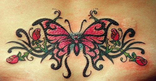Butterfly lower back tattoo with tribal pattern